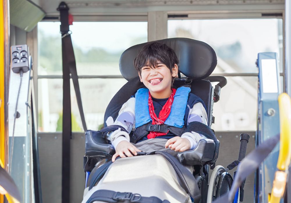 disabled boy in wheelchair smiling in transport van