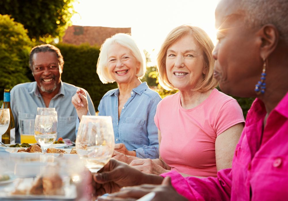 four senior people enjoying an outdoor meal together